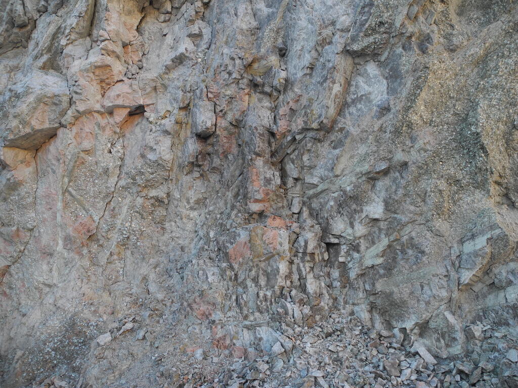 Gro&szlig;e Spodumen Kristalle in der Wand des Steinbruchs und Bruchst&uuml;cke davor