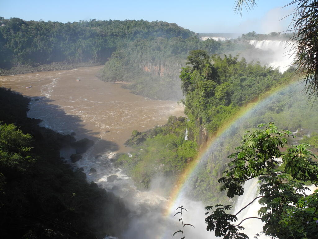 Regenbogen im Spr&uuml;hnebel und Blick auf den unteren Teil des Flusses mit Booten